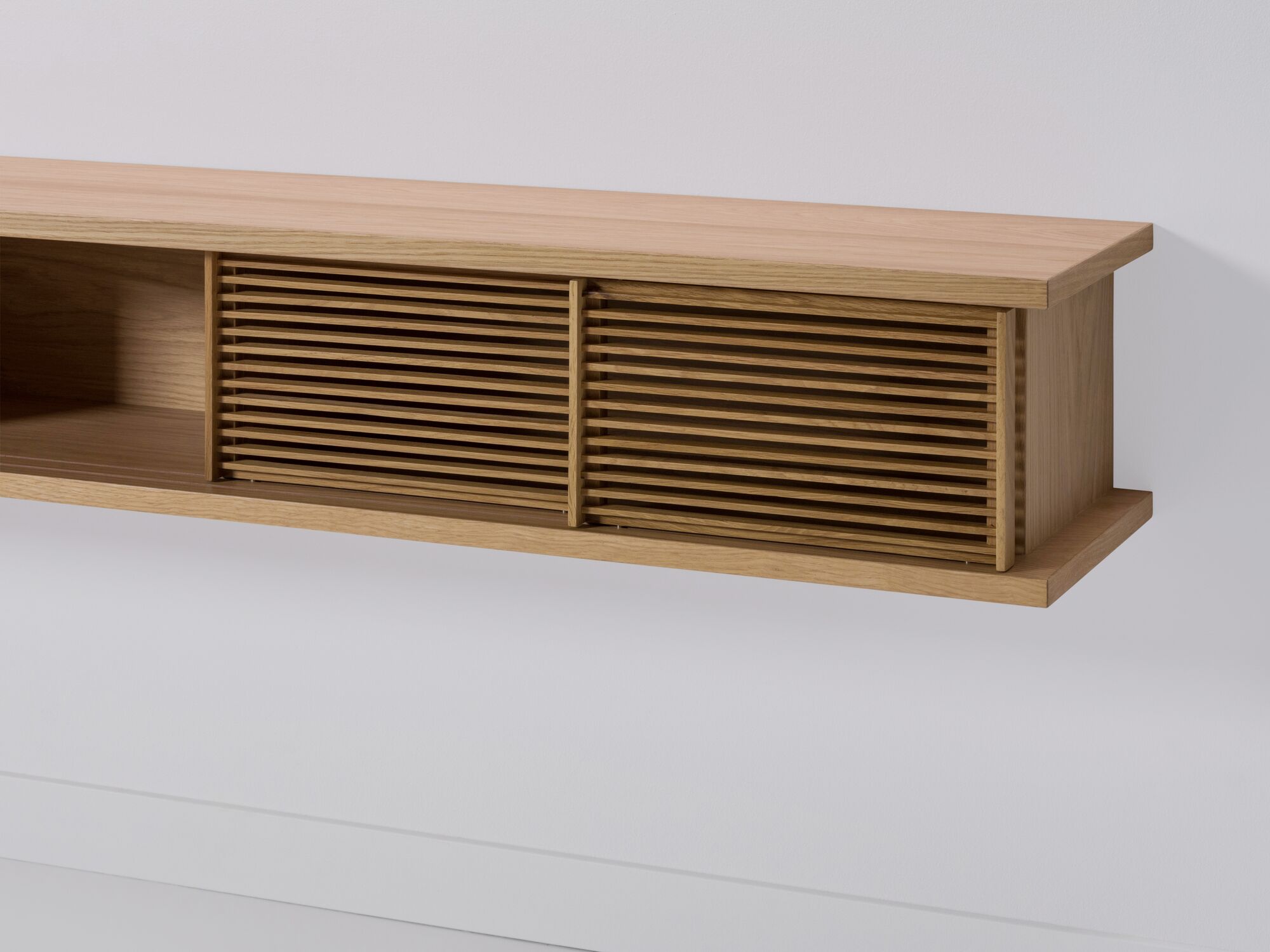 Detail view of large oak floating media unit with slatted doors